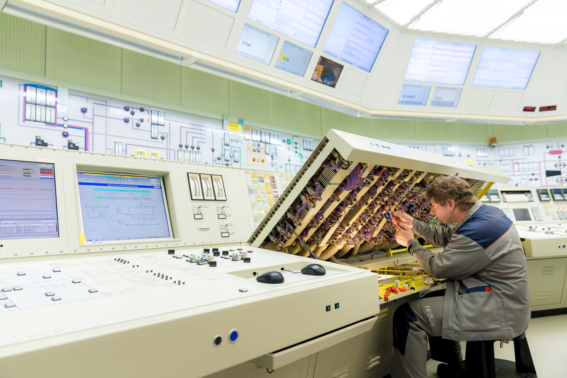 Instandhaltungsarbeiten der Elektrotechnik an einem Bedienungspult im Hauptkommandoraum. 