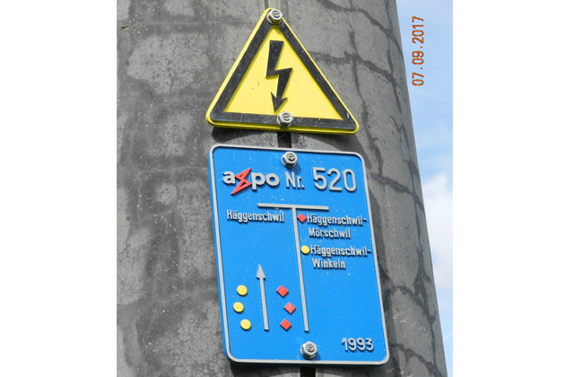 Schild mit Informationen zu Leitung und Masten