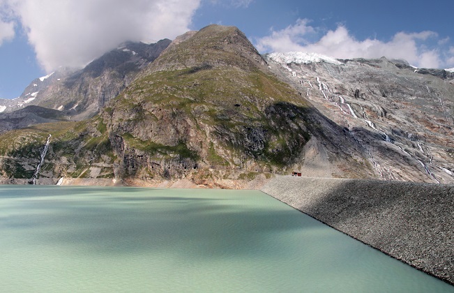 We are in the Canton of Valais at the Mattmark Reservoir above Saas-Almagell. The lake is dammed by a 120-metre high earth-fill dam. The main owners of the Mattmark power plants are Axpo (38.8%) and CKW (27.78%). The average yearly production is 649 million kWh