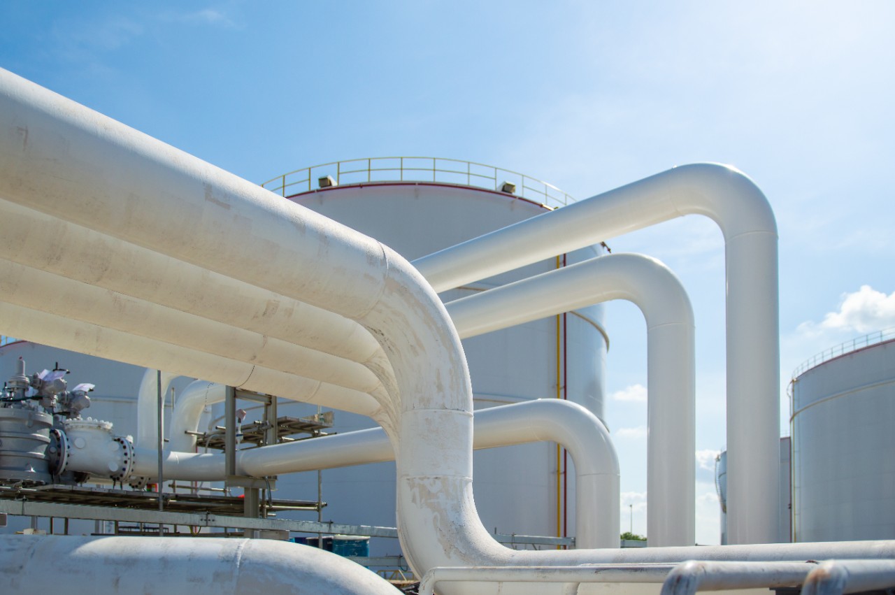 Oil pipeline and Oil storage tank farm in the petroleum refinery.Above ground storage tanks can be used to hold materials such as petroleum,waste matter, water,chemicals,and other hazardous materials.